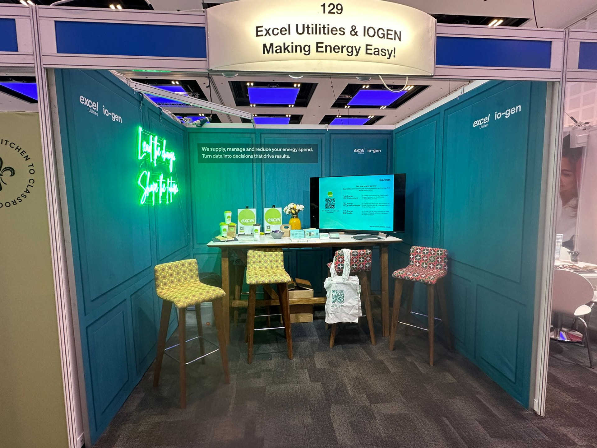 Excel Utilities and io-gen exhibition stand with 'Lead the change, shape the future' neon sign